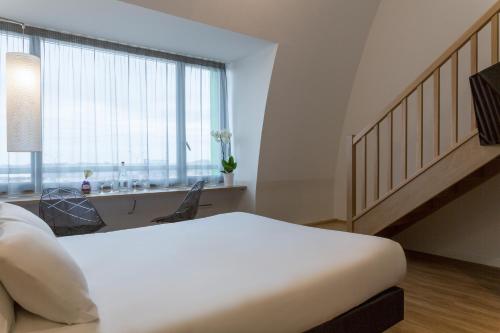 舍诺夫The Originals City, Hôtel Armony, Dijon Sud (Inter-Hotel)的卧室设有一张白色大床和一扇窗户。