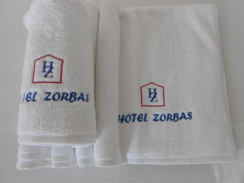 毕达哥利翁左巴斯酒店及一室公寓的两条毛巾,上面有世界佐洛亚斯的词