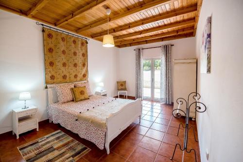 奥比多斯Vale do Grou Natura的卧室设有白色的床和木制天花板。