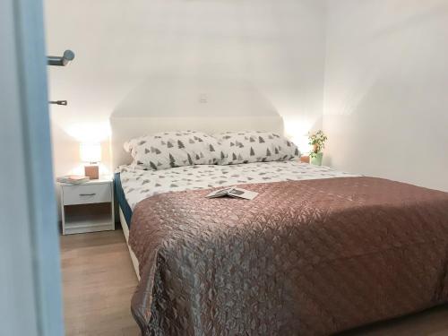 佐尔尼耶戈迪Apartment Tosca near Vintgar and Lake Bled的一间卧室配有一张带棕色毯子和枕头的床。