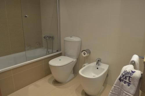 圣卡洛斯拉腊皮塔港口酒店的白色的浴室设有卫生间和水槽。