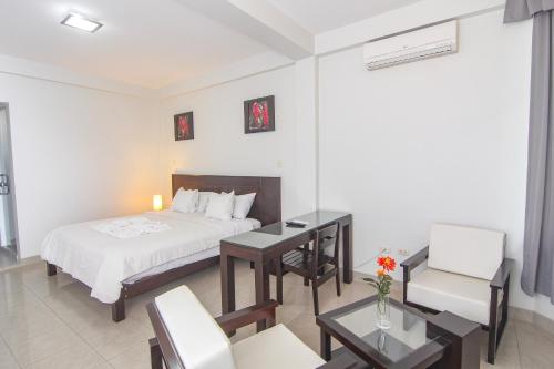 莫约班巴Hotel Rio Mayo的酒店客房带一张床、一张桌子和椅子