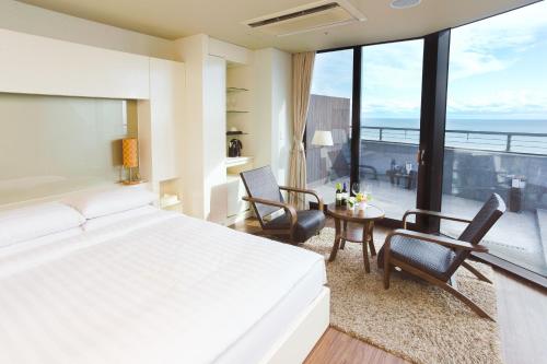 釜山日落商务酒店的一间卧室配有一张床和一张桌子及椅子