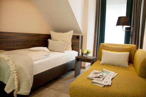 艾汀Hotel Am Moosrain Garni的配有一张床和一把椅子的酒店客房