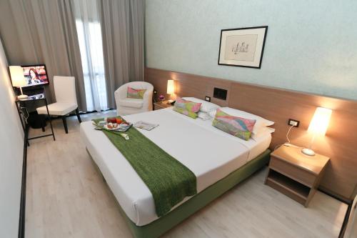 圣伊拉廖登扎论坛酒店的酒店客房带一张大床和一把椅子