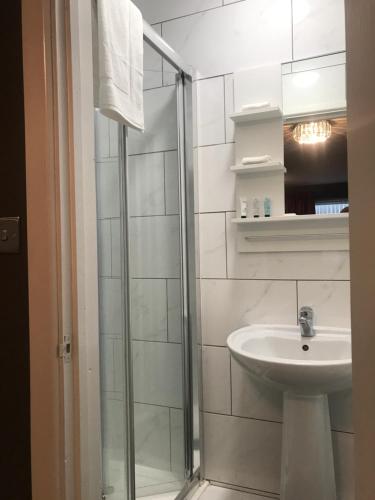 考文垂Bede Apartments的白色的浴室设有水槽和淋浴。