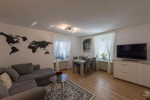 阿劳Muhusin Apartments的客厅配有沙发,墙上挂着世界地图