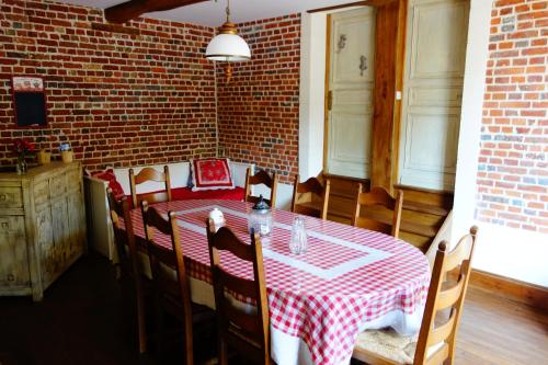 Tigny-NoyelleLa Ferme De Tigny的一间用餐室,配有红色和白色的桌子和椅子