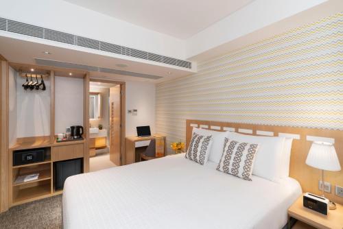 香港香港莎玛港岛北服务式公寓的卧室配有白色的床和书桌
