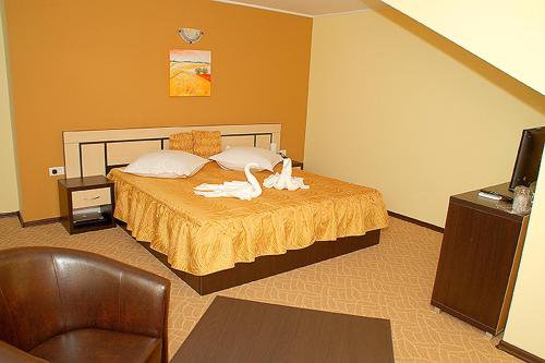 曼加利亚Vila Maritimo的一间卧室配有一张带两个天鹅的床