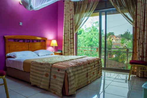 坎帕拉Landmark View Hotel的一间卧室设有一张大床和一个大窗户