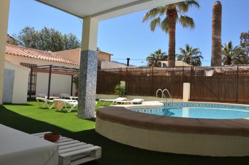 德尼亚奥库洛公寓的后院设有游泳池和带桌子的庭院。
