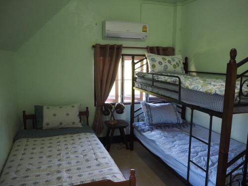 夜占县Imm Jai Smile Cottage的客房设有两张双层床和一扇窗户。