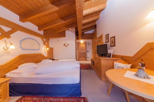 圣马蒂诺-迪卡斯特罗扎Malga Ces的一间卧室配有一张大床和一张桌子