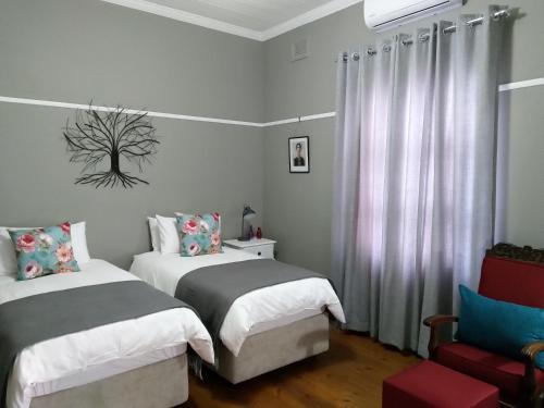彼得马里茨堡Casa Mia的一间卧室配有两张床和椅子