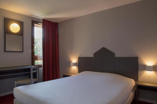奥多斯The Originals City, Hôtel Amys, Tarbes Sud (Inter-Hotel)的卧室设有一张白色大床和一扇窗户。