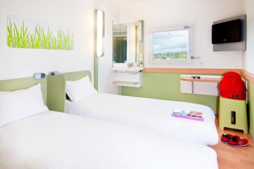 罗莫朗坦罗莫朗坦宜必思经济型酒店的酒店客房设有两张床和窗户。