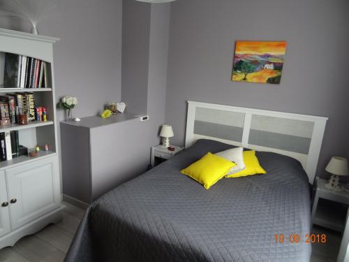 MornantL'Olivier的一间卧室配有一张带两个黄色枕头的床