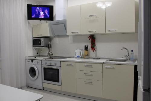 敖德萨Apartments Butterfly Wing的厨房配有白色橱柜、洗衣机和烘干机
