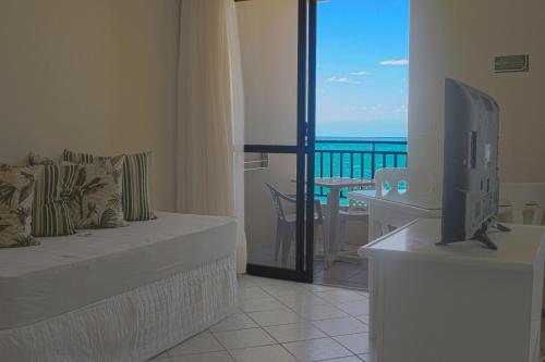 弗洛里亚诺波利斯棕榈滩公寓式酒店的带电视的客厅和海景阳台。