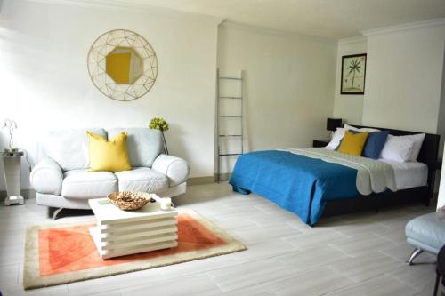 欧丘里欧Ambleside & Turtle beach towers的一间卧室配有一张床和一张沙发