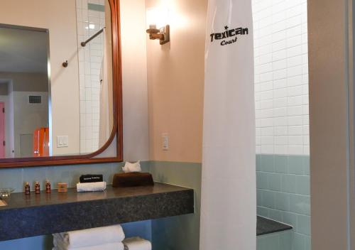 欧文Texican Court, by Valencia Hotel Collection的浴室配有盥洗盆、镜子和毛巾