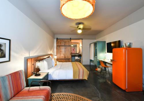 欧文Texican Court, by Valencia Hotel Collection的一间卧室配有一张床、一张桌子和一张沙发