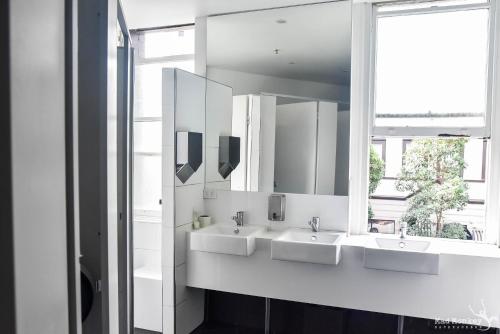 悉尼Mad Monkey Bayswater的一间带三个水槽和镜子的浴室