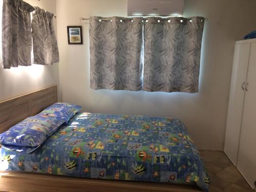 苏塞克斯入口里维埃拉卡拉万假日公园的一间卧室配有一张带床罩的床和窗户