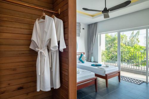 贡布皮帕利精品酒店的一间房间,配有一张床和墙上的浴袍