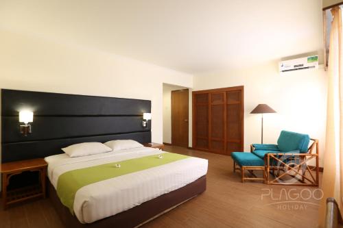 努沙杜瓦普拉戈假日酒店 的酒店客房带一张大床和一把椅子