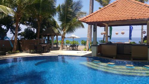 特贾库拉Camplung Beach Villa Tejakula with 6 Bedrooms and Pool的一个带凉亭的游泳池以及大海