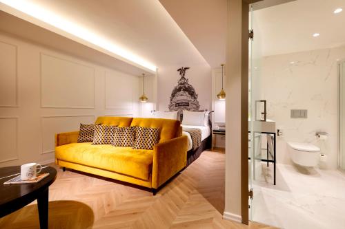 马德里马德里迩柔萨达尔格兰大街酒店的客厅配有黄色的沙发和床。