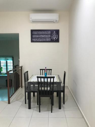 马六甲Rumah Melaka的一间用餐室,配有黑色的桌子和椅子