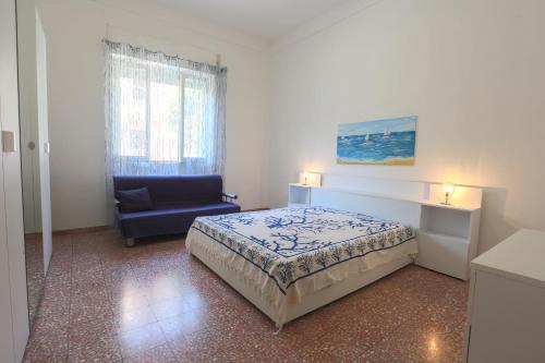托雷圣乔万尼乌Villetta Angela的一间卧室配有一张床和一张蓝色椅子