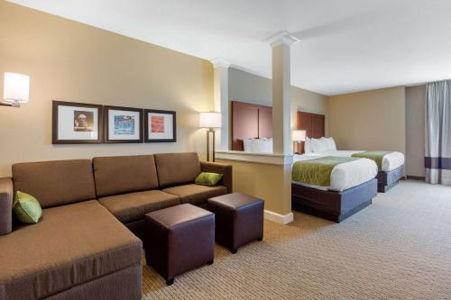 伯明翰Comfort Inn & Suites At CrossPlex Village的酒店客房设有一张沙发和一张床