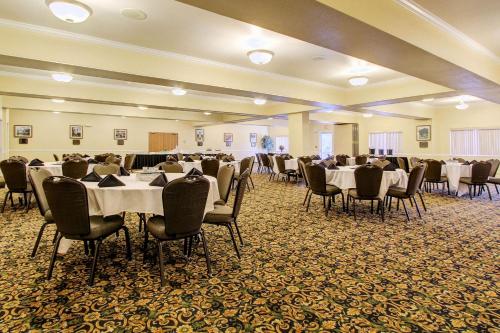 安克雷奇Clarion Suites Anchorage Downtown的宴会厅配有白色的桌椅