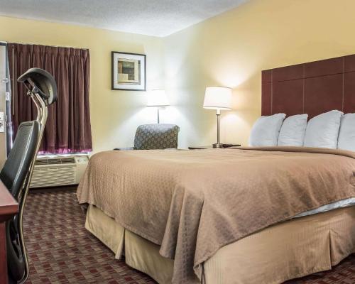 麦迪逊麦迪逊品质酒店的酒店客房带一张大床和一把椅子
