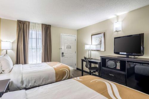 奥本Quality Inn Auburn University Area的酒店客房设有两张床和一台平面电视。