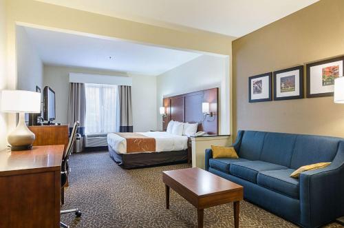 斯普林代尔品质套房酒店的酒店客房,配有床和蓝色的沙发