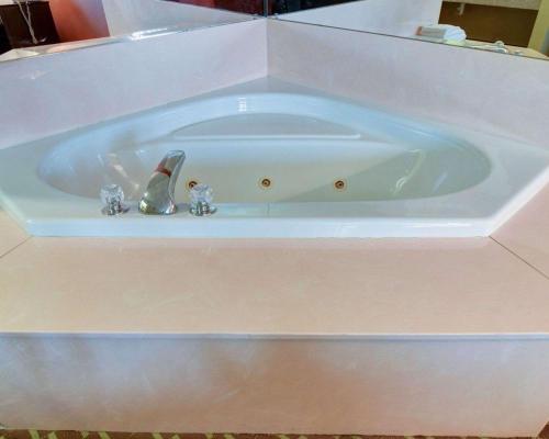 派恩布拉夫Quality Inn & Suites Pine Bluff AR的白色浴缸内有2个雕像