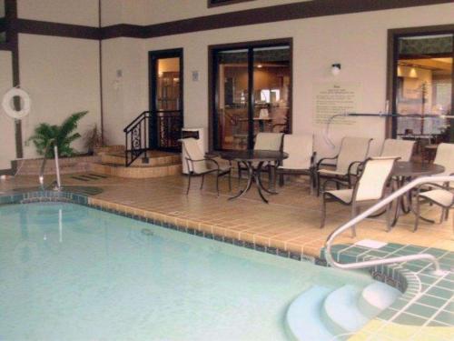 瑟西Quality Inn & Suites Searcy I-67的大楼内一个带椅子和桌子的游泳池