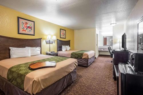 瑟西Econo Lodge Inn & Suites Searcy的酒店客房设有两张床和一台平面电视。