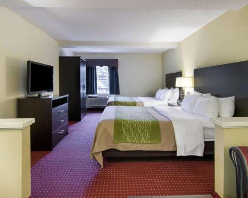 小石城Quality Inn & Suites Little Rock West的酒店客房设有两张床和一台平面电视。