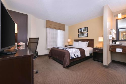 费耶特维尔Sleep Inn Fayetteville North的配有一张床和一台平面电视的酒店客房