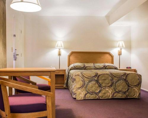 TaylorRodeway Inn Silver Creek Inn的卧室配有1张床、1张桌子和1把椅子