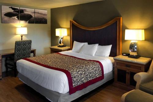 弗拉格斯塔夫Rodeway Inn Flagstaff East Route 66的酒店客房设有一张大床和两盏灯。