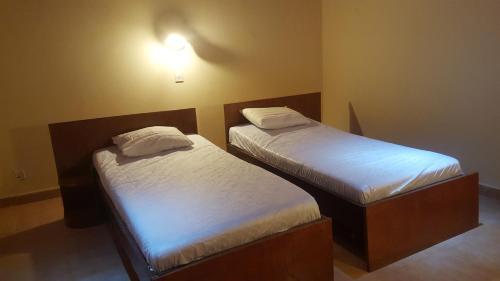 TubayaYuna Village Garden Resort的带两张床的小房间,带水电