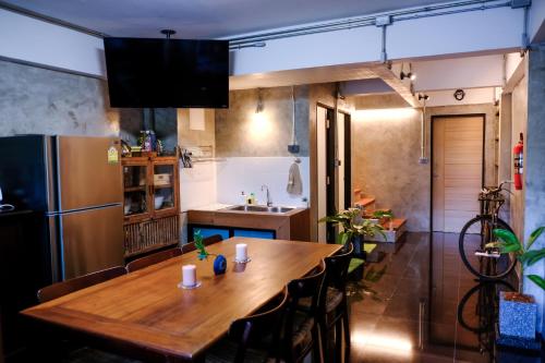 清迈Baan Lung Poshtel的厨房配有木桌和冰箱。