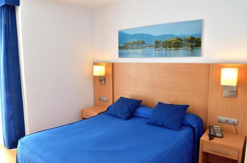 圣卡洛斯拉腊皮塔港口酒店的一间卧室配有蓝色的床和蓝色枕头